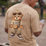 Man wearing a Navalook beige oversized t-shirt with a teddy bear graphic walking on a city street