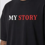 Man wearing a black oversized streetwear T-shirt with 'Scary Story' printed on the back in white and red text.