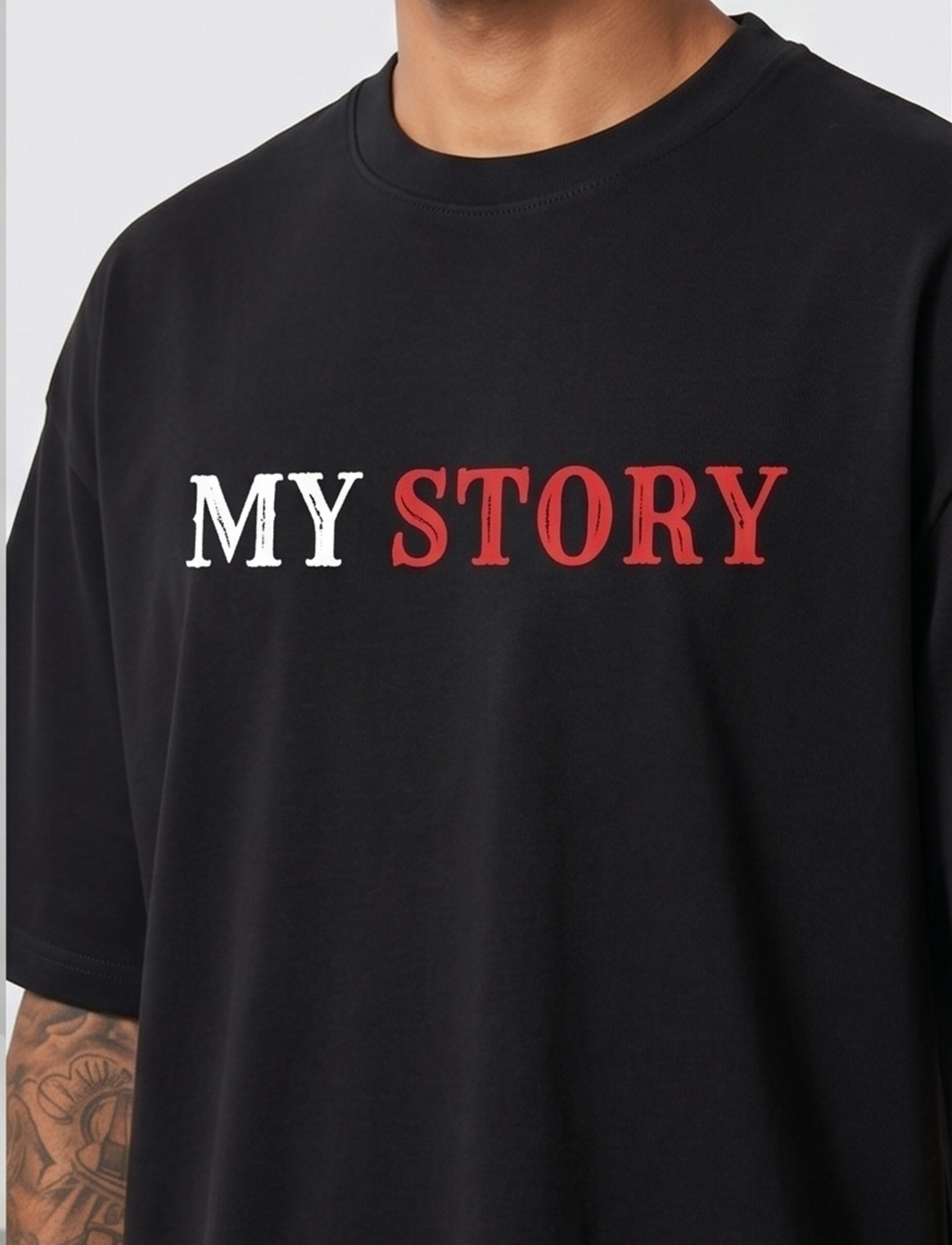 Man wearing a black oversized streetwear T-shirt with 'Scary Story' printed on the back in white and red text.